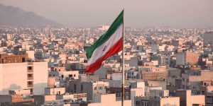 Iranian flag waving with cityscape on background in Tehran, Iran