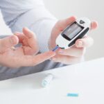person measures blood sugar with glucometer