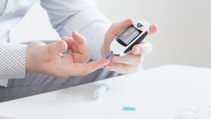 person measures blood sugar with glucometer